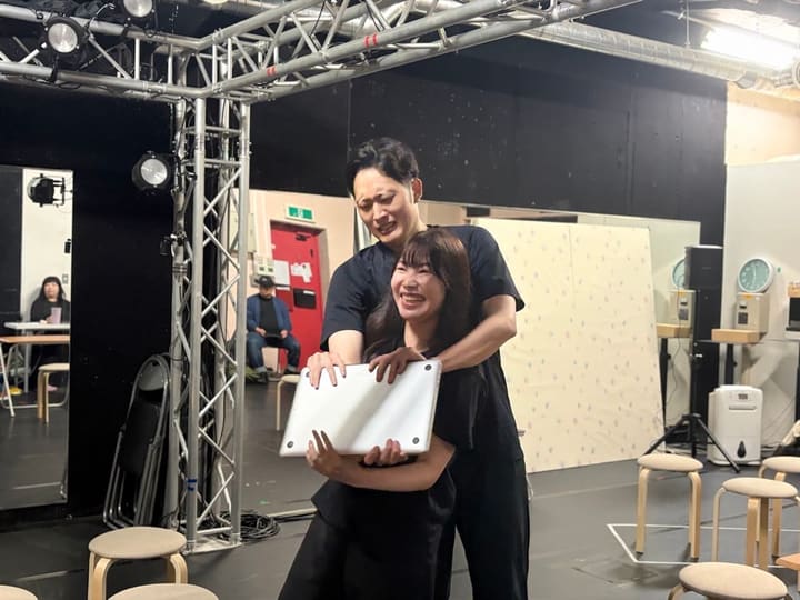 背中から抱きとめる芝居を、笑いながら確かめる2人の出演者｜劇団カスタリア 芝居稽古
