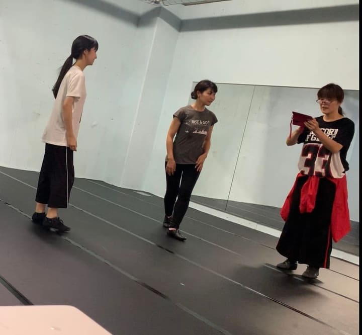 手元を見ながら振りを確認する団員と、向き合って立つ2人｜劇団カスタリア「DAHLIA」ダンス稽古