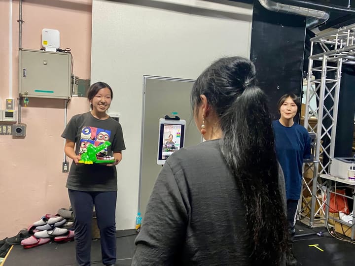 緑のワニのおもちゃを手に、配信用タブレットの前で笑う団員｜劇団カスタリア 稽古オフショット