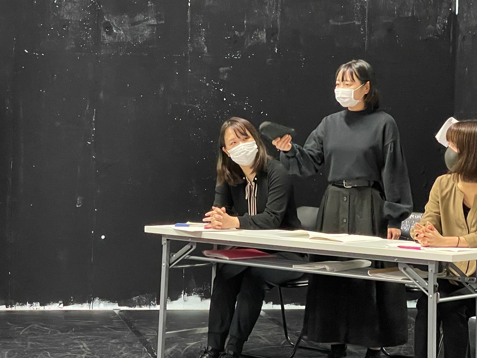長机の奥に立ち、手を差し出して身振りで訴える出演者｜劇団カスタリア「ジャッジメント」芝居稽古