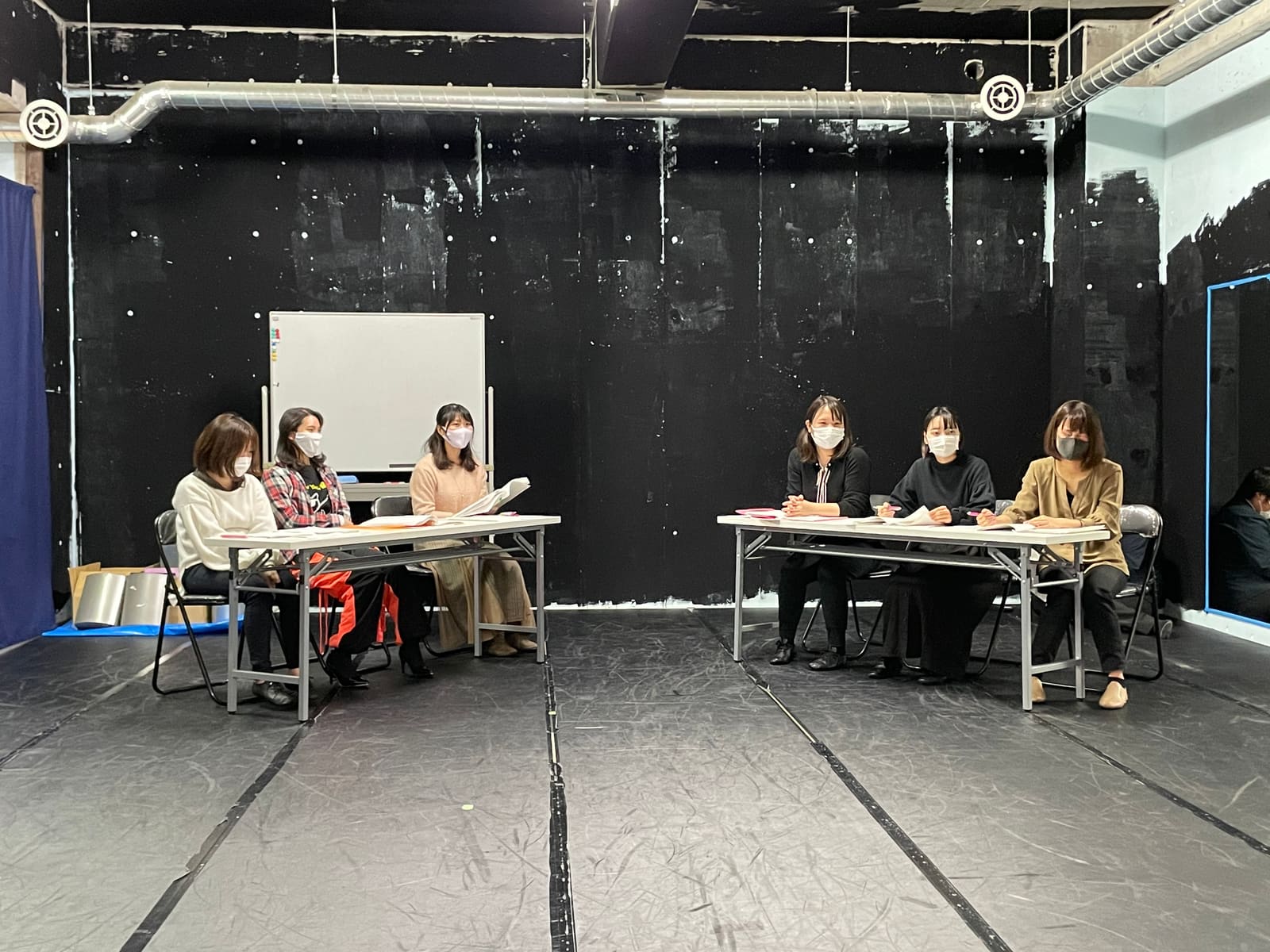 二つの長机に三人ずつ着き、台本を手に議論の場面を演じる出演者たち｜劇団カスタリア「ジャッジメント」芝居稽古