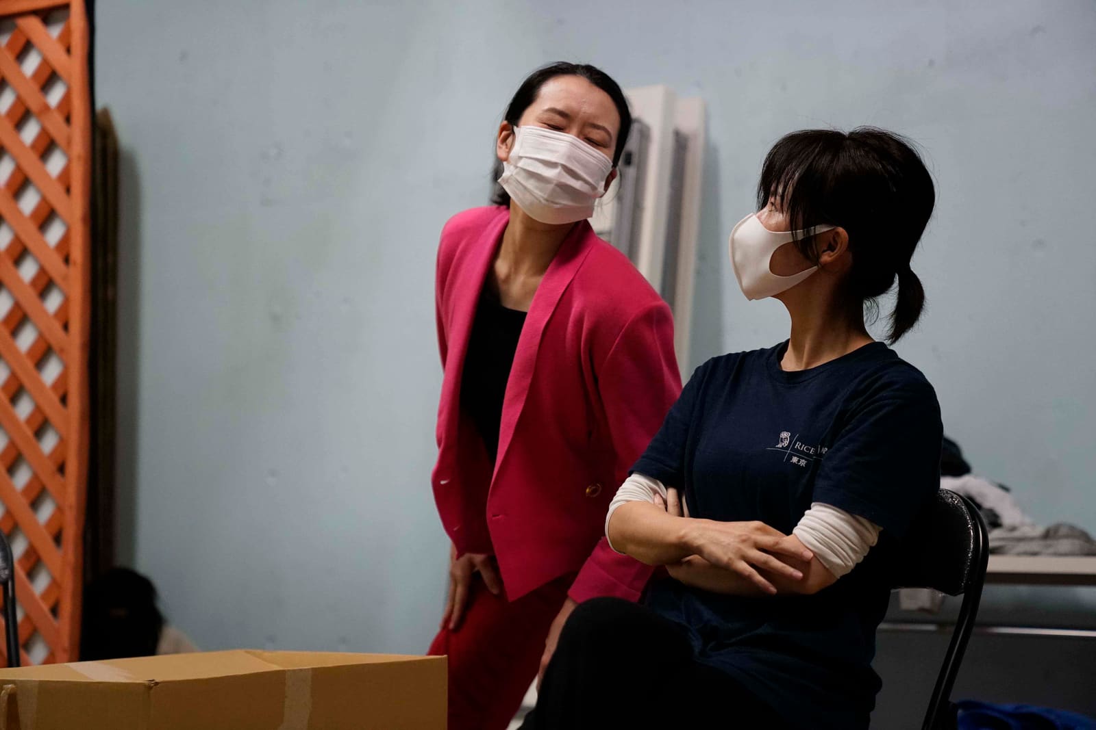 ピンクのスーツ姿で、椅子に座り腕を組む相手に語りかける出演者|劇団カスタリア 芝居稽古