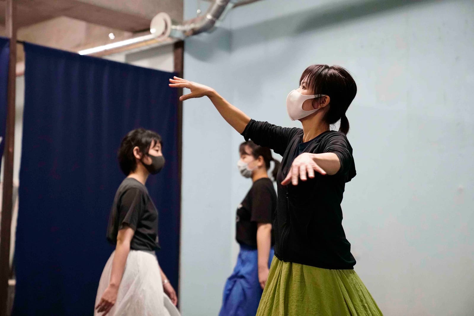 緑のスカートで両腕を前へ伸ばす団員と、色違いのスカートで続く仲間たち|劇団カスタリア ステージング稽古