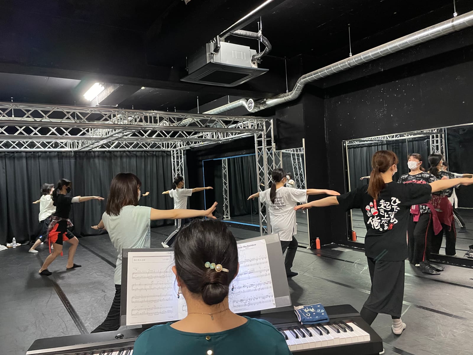 ピアノの伴奏に合わせ、両腕を横に開いて脚を踏み出す団員たち｜劇団カスタリア ダンス基礎練習