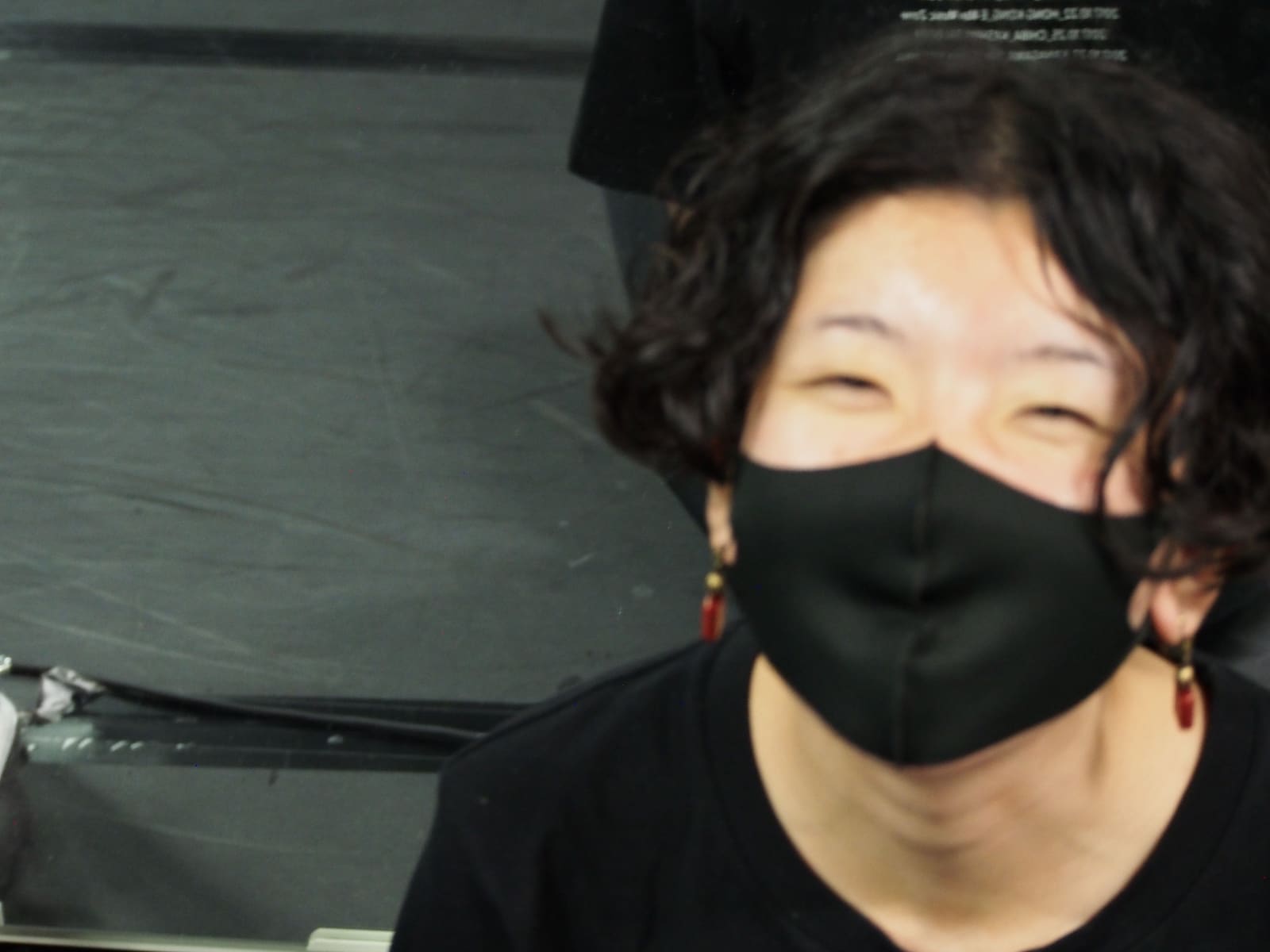 黒いマスクの上で目を細めて笑う団員のアップ｜劇団カスタリア 稽古オフショット