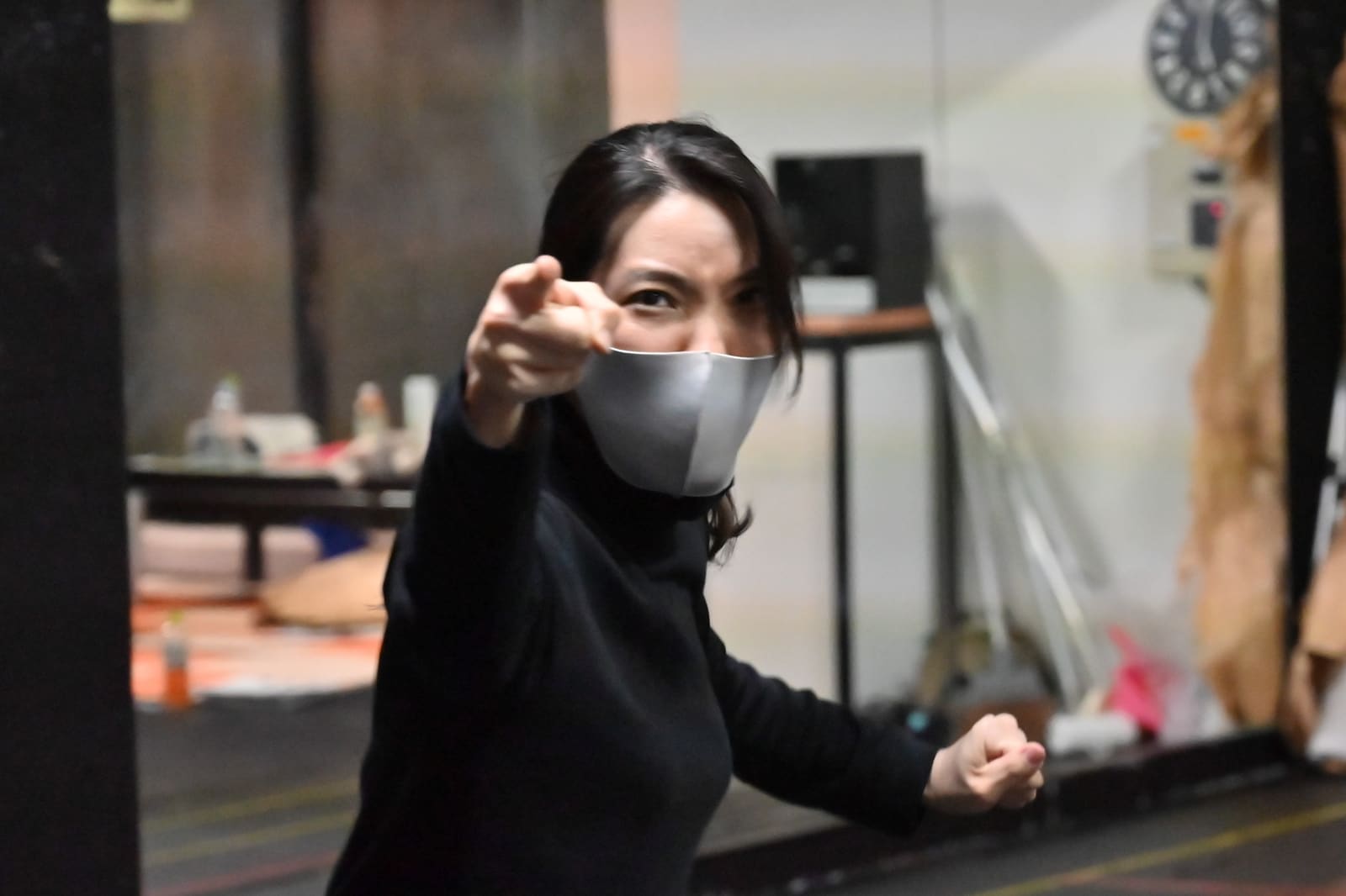 黒い服で正面をまっすぐ指さし、こぶしを握る団員|劇団カスタリア 立ち稽古