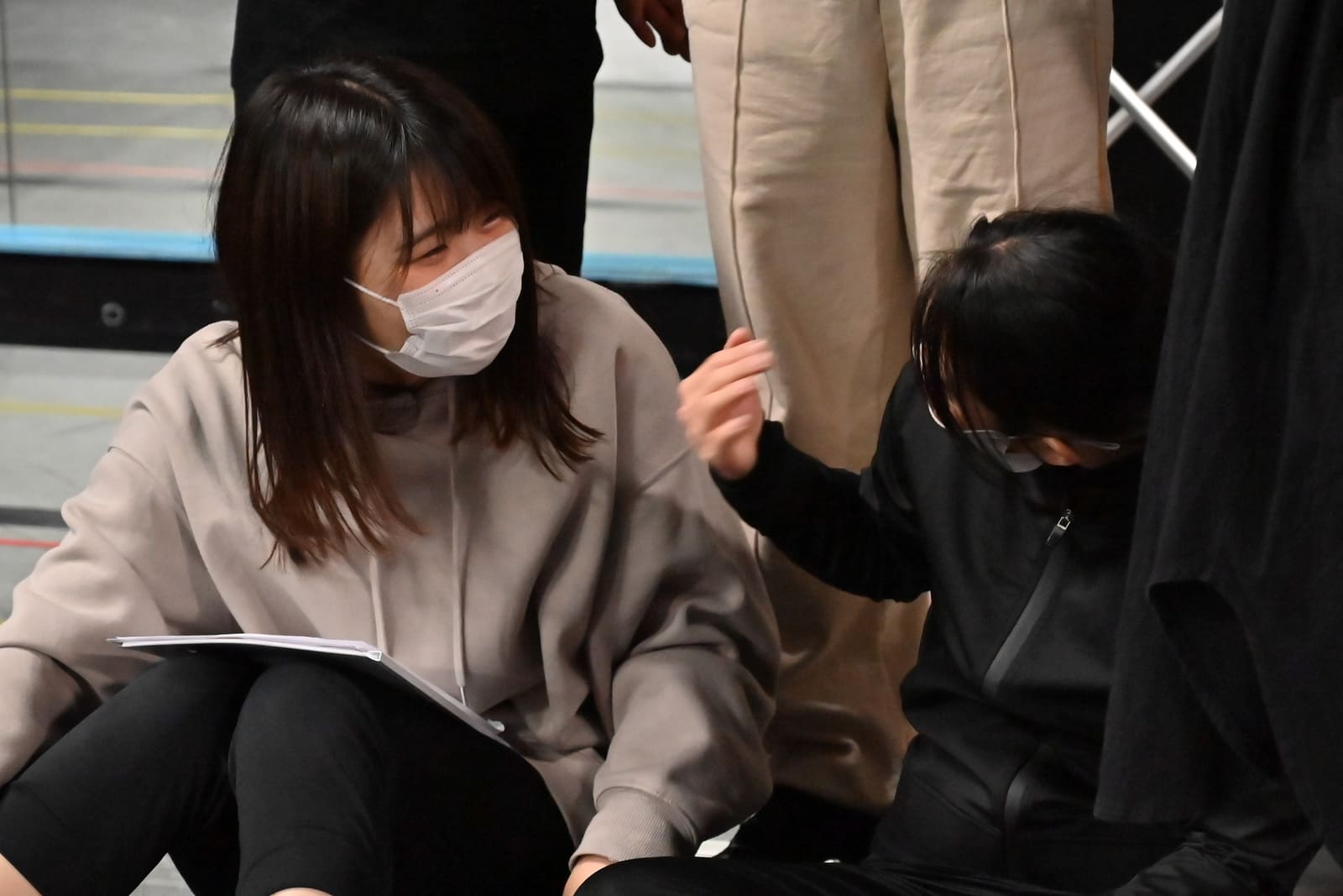 床に座って台本を膝に広げ、隣の団員と場面を確認する様子|劇団カスタリア 演技稽古