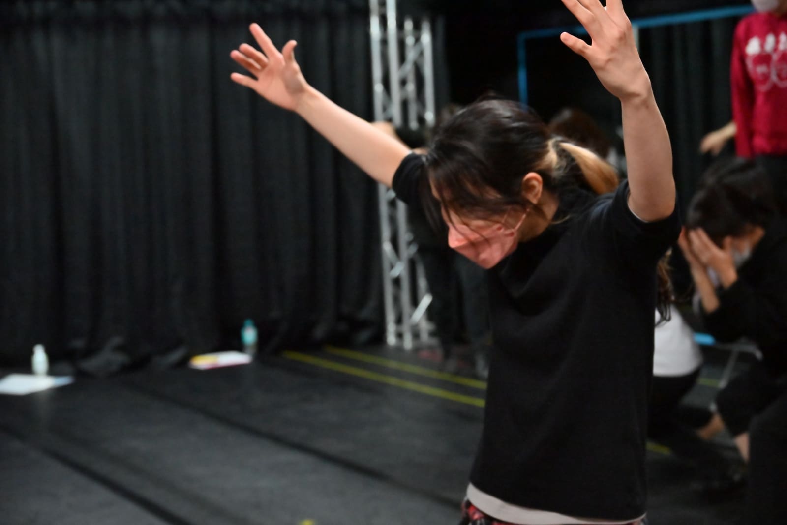 両腕を頭上に伸ばし、上体を沈める振りを踊る団員たち｜劇団カスタリア ナンバー稽古