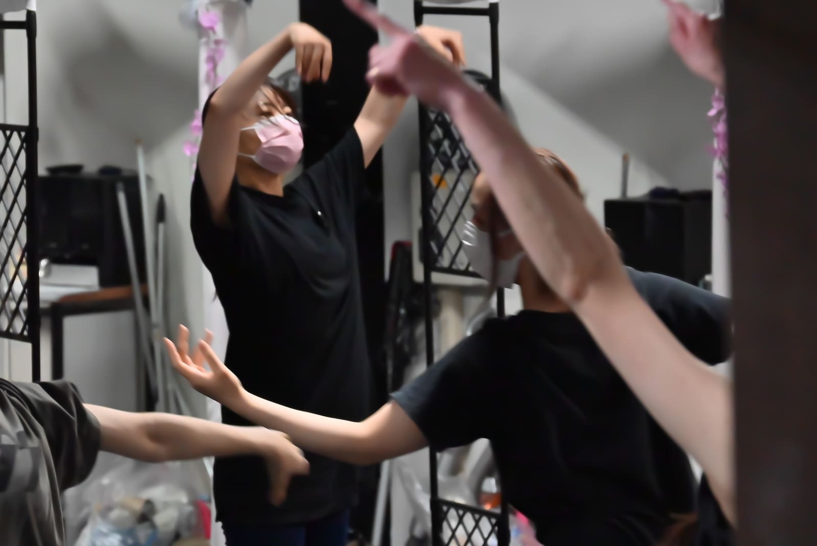 鏡張りの壁の前で腕を頭の上で交差させ、振りを合わせる団員たち｜劇団カスタリア「オーブ」ダンス稽古