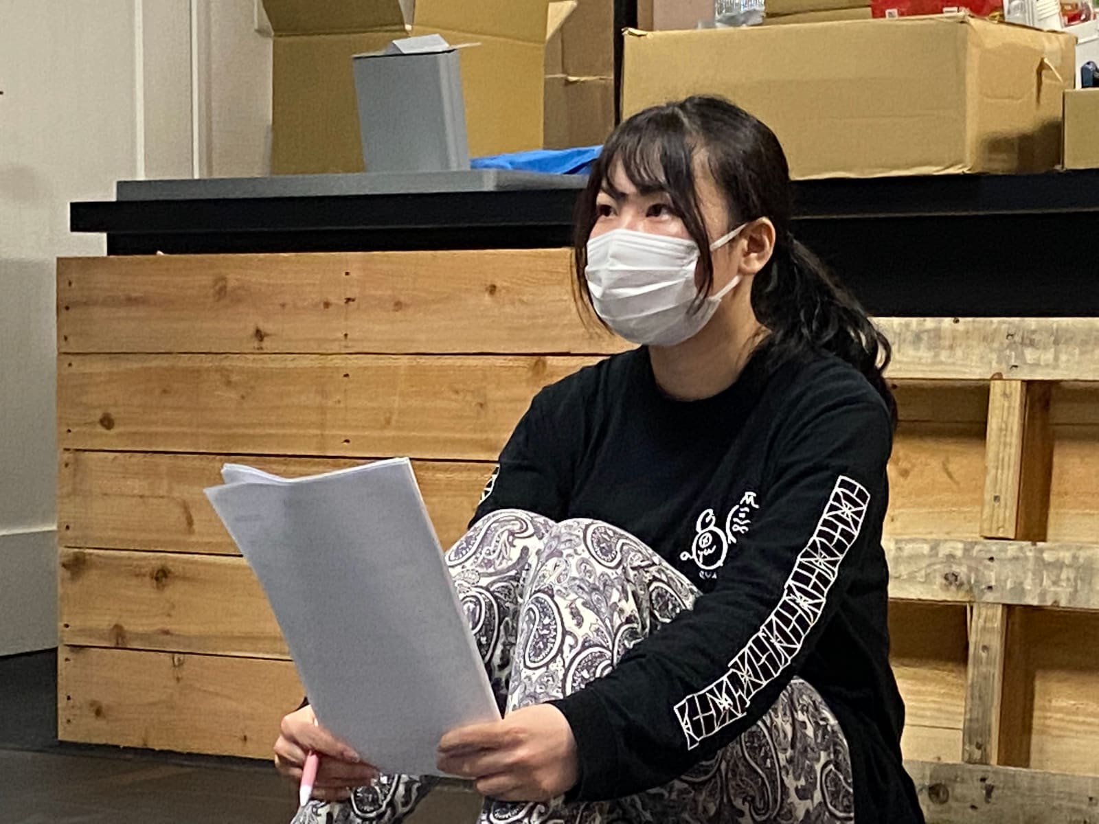 台本とペンを手に床へ座り、稽古を見上げる団員｜劇団カスタリア 稽古
