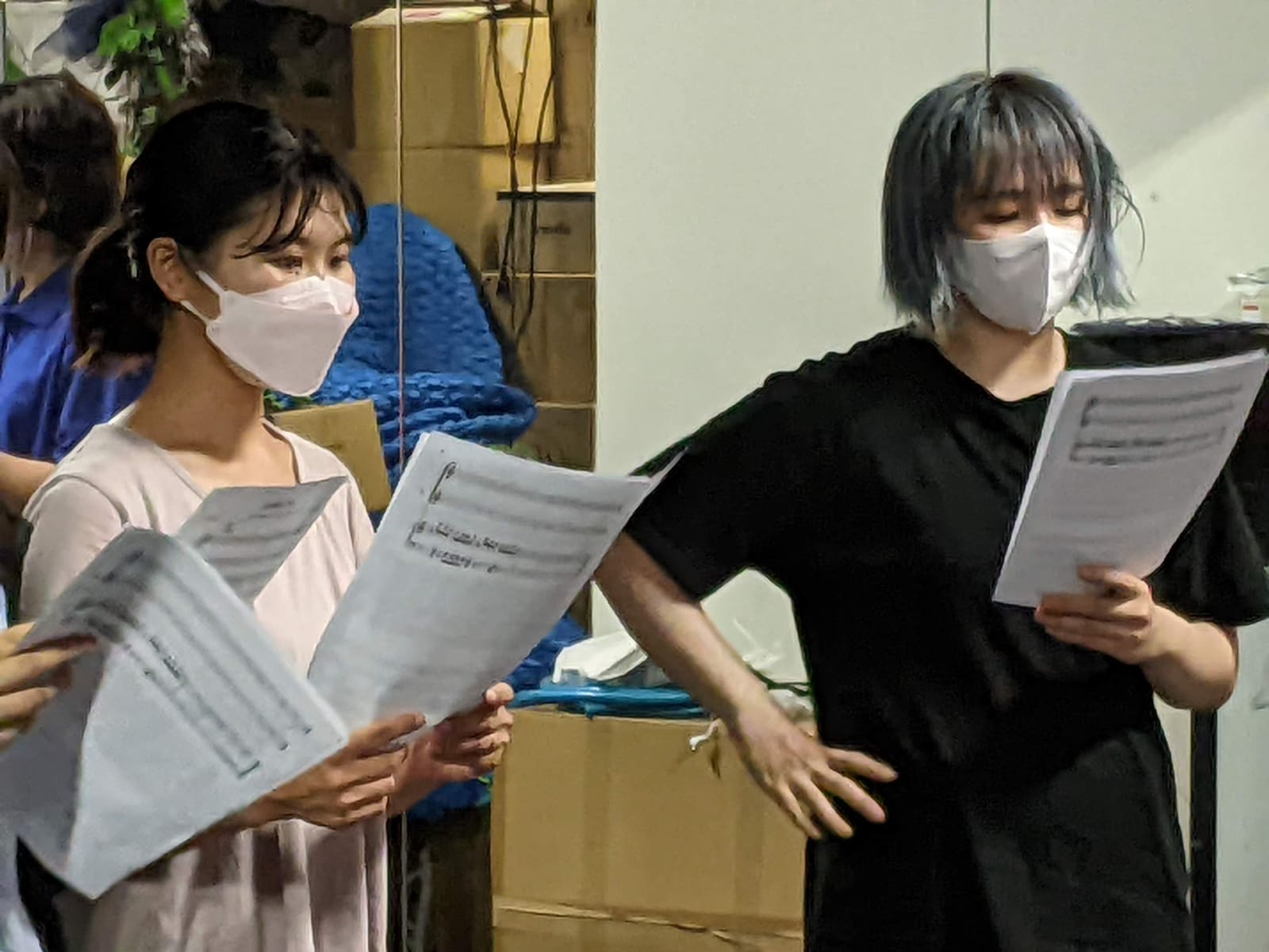 楽譜を持ち、腰に手を当てて動きながら歌う団員2人｜劇団カスタリア 歌と演技の稽古