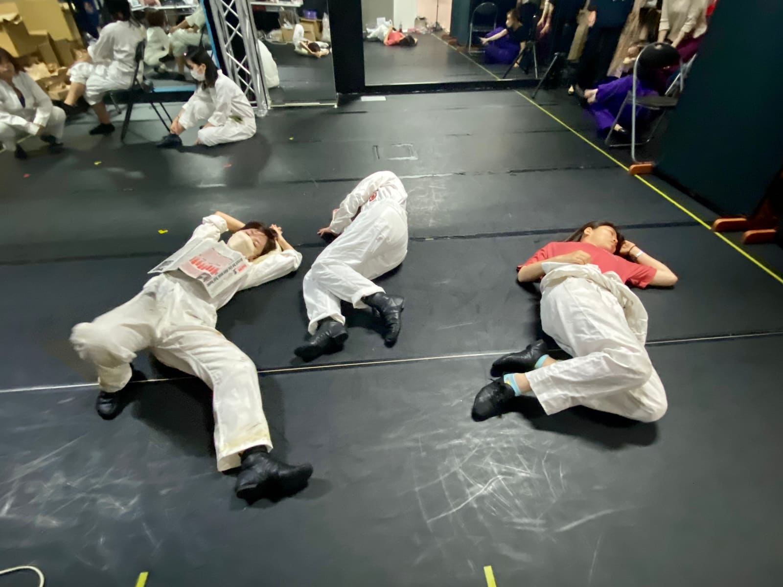 白いつなぎの衣裳のまま床に寝そべって休む出演者3人|劇団カスタリア 衣裳パレード