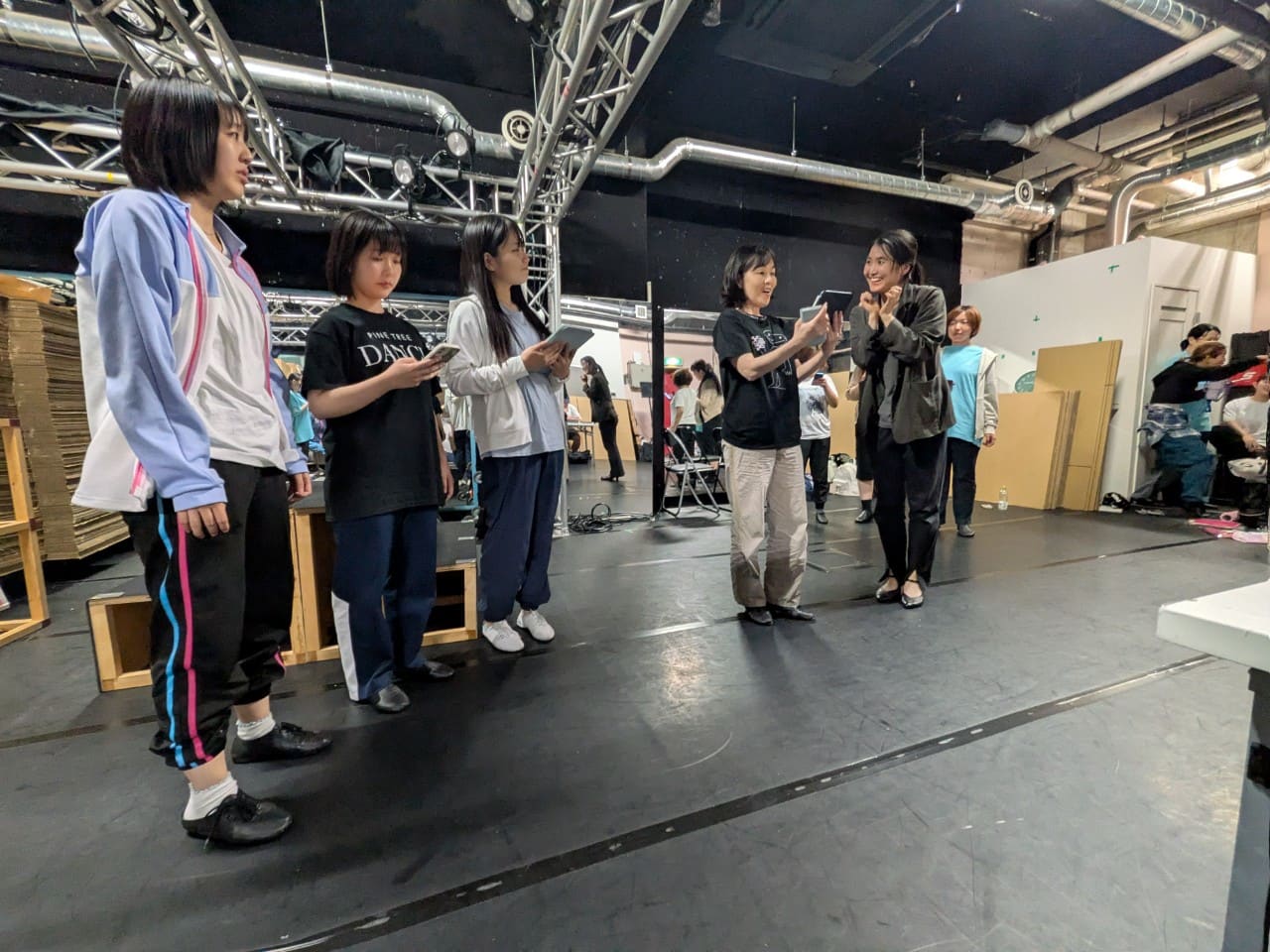 タブレットを手に、講師の説明を聞きながら振りを覚える出演者たち｜劇団カスタリア「清子と桃香」振り付け稽古