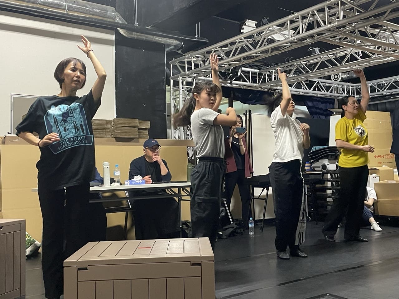大道具の木箱を置いた舞台で、腕を上げる振りを合わせる出演者たち｜劇団カスタリア「清子と桃香」舞台美術の確認