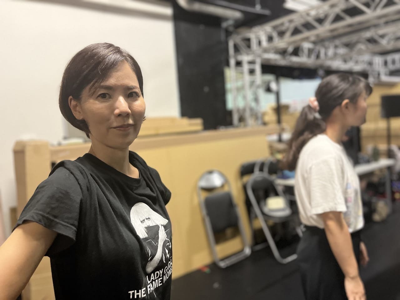 稽古場でカメラに顔を向ける出演者と、後ろで立ち位置につく仲間|劇団カスタリア「清子と桃香」稽古
