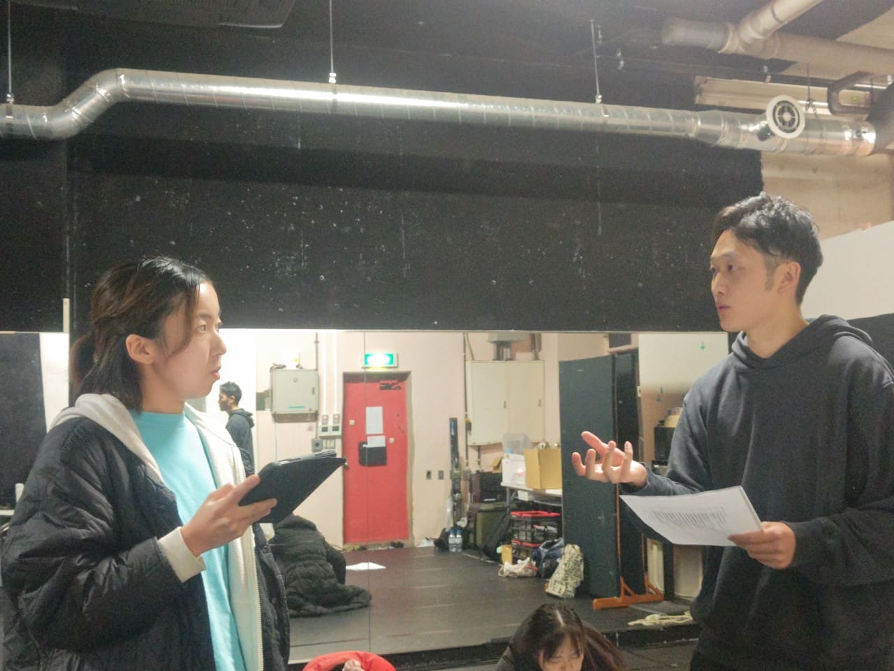 台本とタブレットを手に、間の取り方を話し合う団員2人｜劇団カスタリア 演技稽古