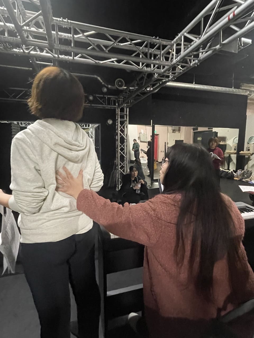 背中に手を添えて発声を指導する講師と、それに応える団員｜劇団カスタリア 歌のレッスン