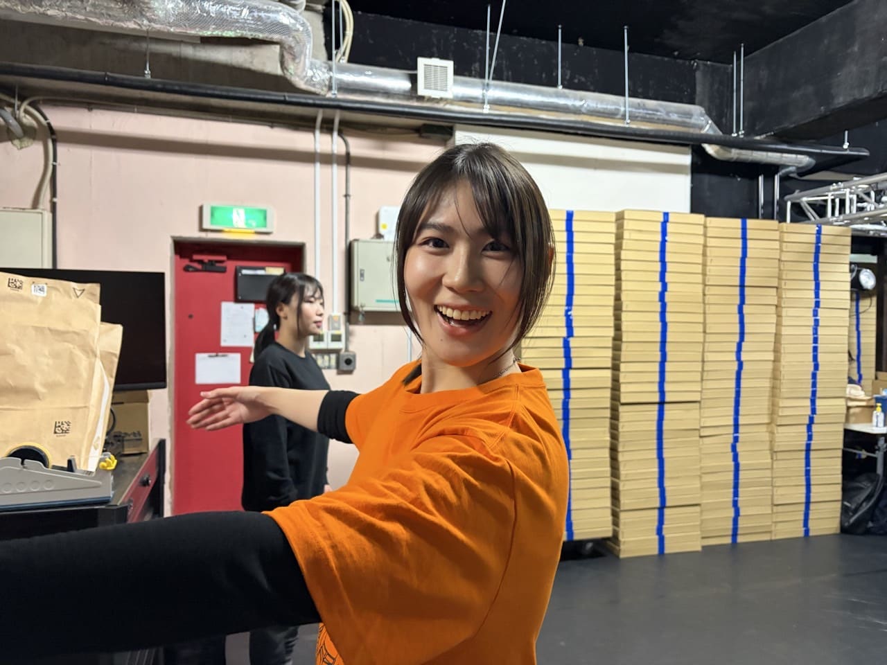 腕を横に伸ばしたポーズで、笑顔でカメラを振り返る団員|劇団カスタリア ダンス基礎練
