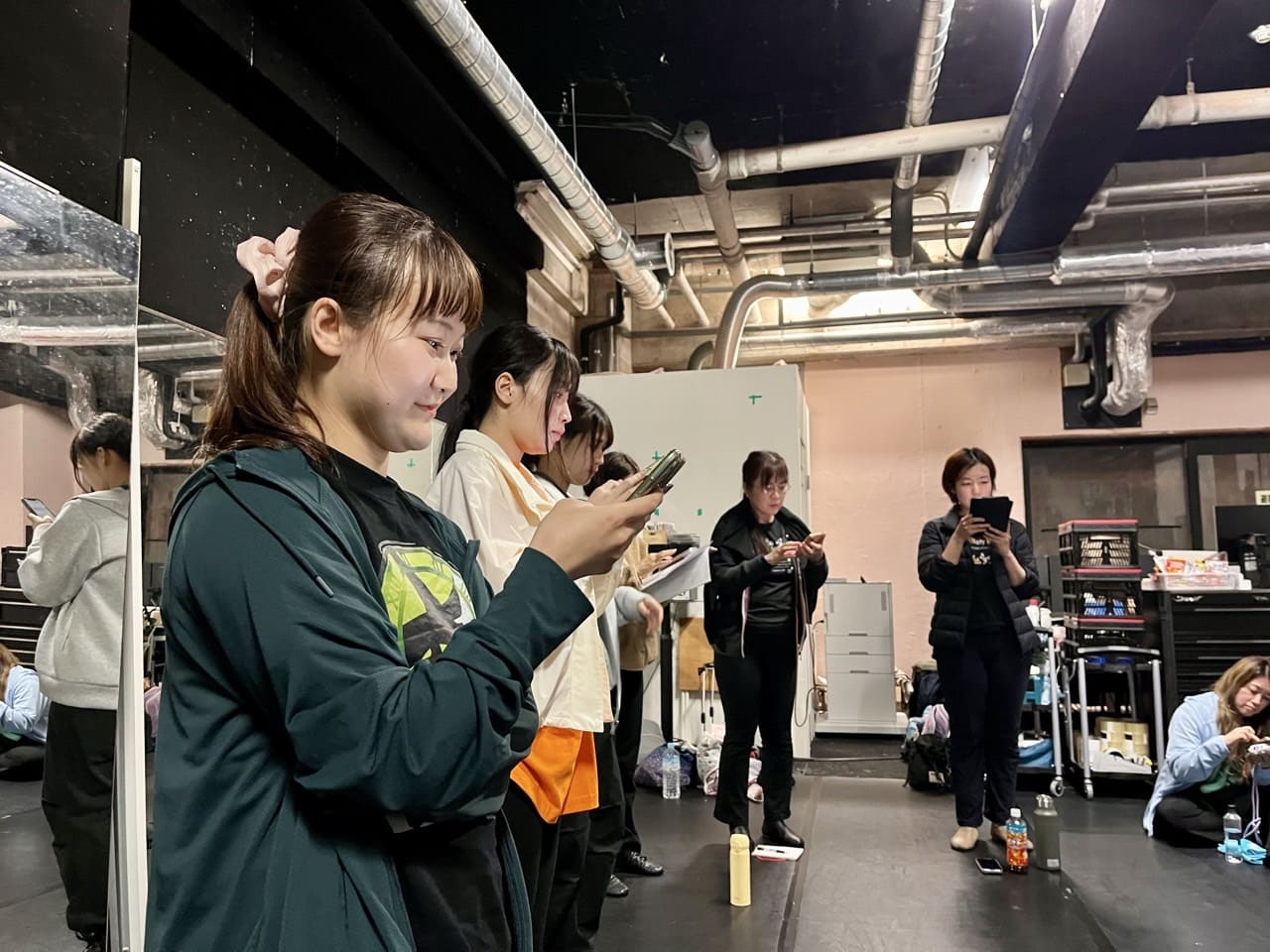 スマートフォンで配られたばかりの台本を読み込む団員たち｜劇団カスタリア「金曜日の食卓」稽古
