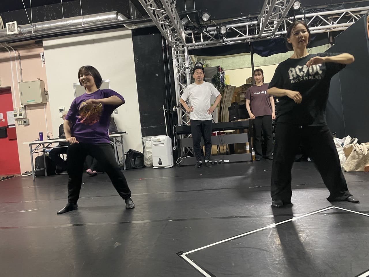 腰を落としたポーズで振付を踊る団員と、後ろで見守るメンバー｜劇団カスタリア「金曜日の食卓」ダンス基礎練習