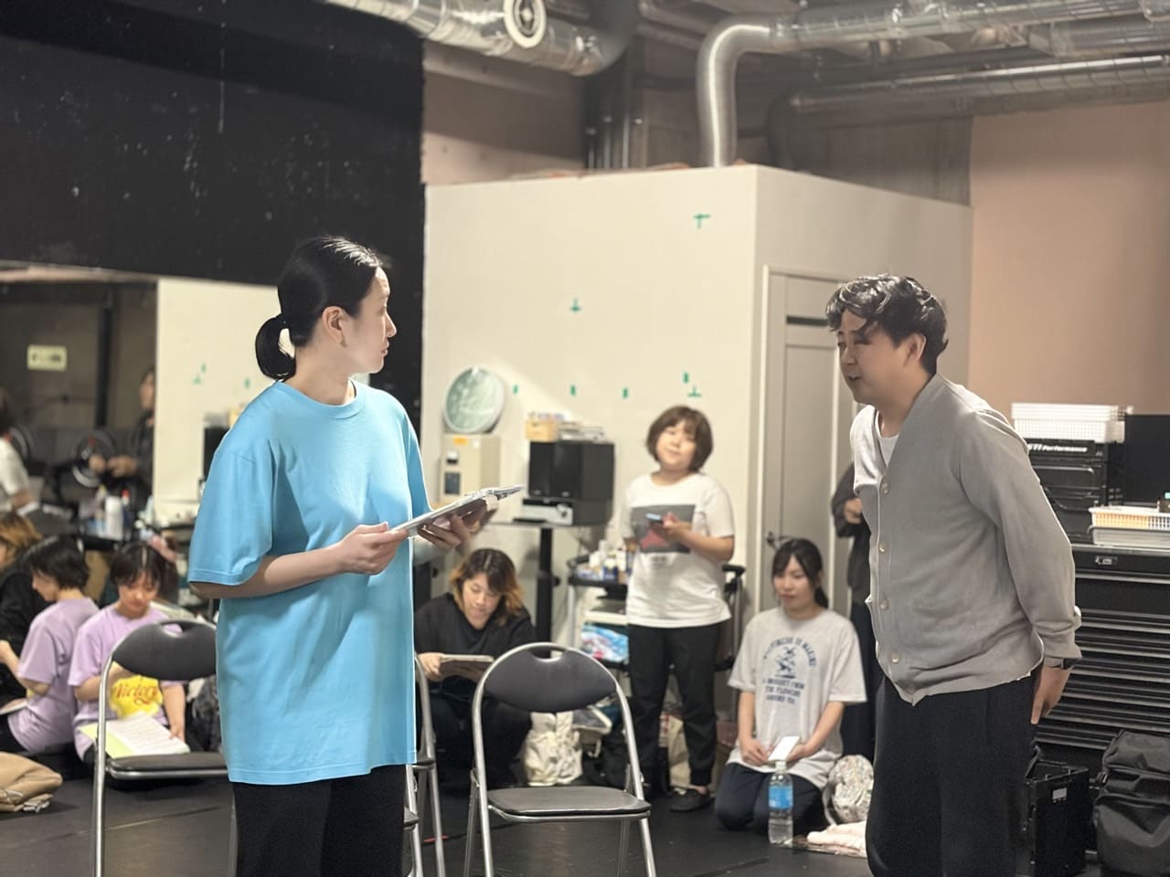 台本を手に相手役と向き合って台詞をやり取りする団員と、それを見守るメンバー｜劇団カスタリア「金曜日の食卓」芝居稽古